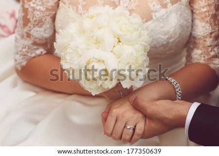 Detail of bride and groom holding hands