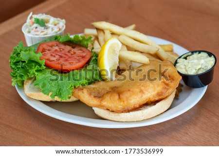 Fried fish sandwich with fries chip coleslaw
 Royalty-Free Stock Photo #1773536999