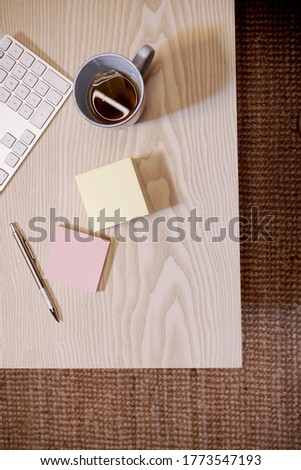 flat lay desk with keyboard block notes and tea