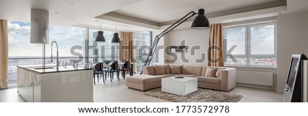 Panorama of kitchen and dining area open to living room in amazingly designed apartment with city view Royalty-Free Stock Photo #1773572978