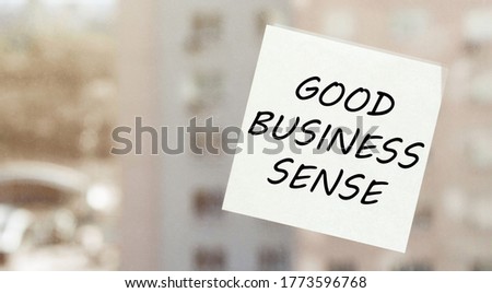 white paper with text GOOD BUSINESS SENSE on the window