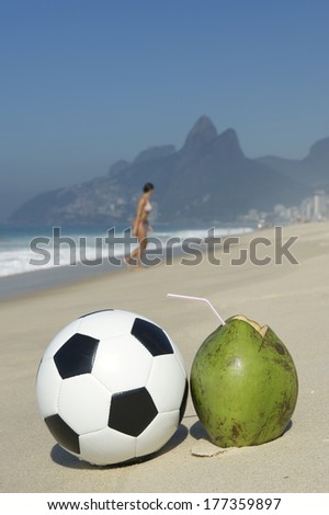 Fresh green drinking coconut coco gelado next to football soccer ball Ipanema Beach Rio de Janeiro Brazil