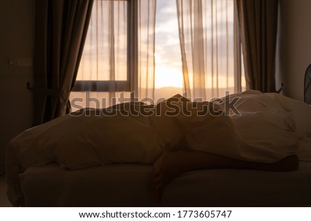 Foot sleeping in the morning at dawn, the girl hangs down the bed. Spy photo. Deep sleep