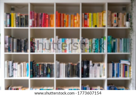 Blurred image of white wooden bookcase filled with books in a UK home setting Royalty-Free Stock Photo #1773607154