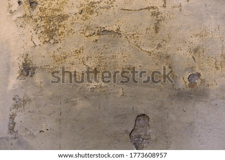 Grunge plastered wall with cracks. Dirty and weathered cracked stucco on the wall of old building. Retro concept. Abstract texture or background.