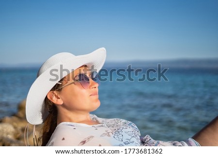 Beautiful women enjoy sunbathing on the beach.Sunset sunbathing stock photo.