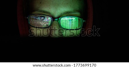 hacker at computer data reflecting in eyeglasses