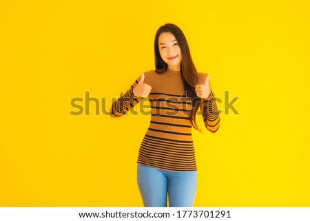 Portrait beautiful young asian adult woman smile with many action on yellow isolated background