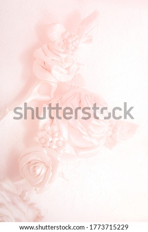 Pink rose buds on a wall with venetian stucco. Delicate background for a wedding card, invitation, business cards. Blurred