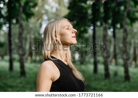 Profile of a relaxed woman breathing deep fresh air in the forest. Great pleasure.