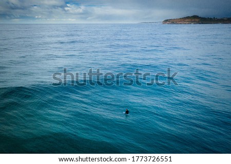 Aerial view of Surfer riding the wave in the ocean in Sydney Australia early morning
