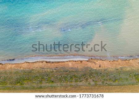 Aerial view of sandy beach and sea with waves