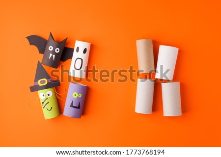 Child creates decorations for Halloween party from toilet roll. Easy eco-friendly DIY master class, craft for kids. Materials for creativity, recycle reuse concept of holiday art activities