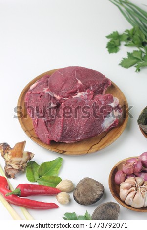 Daging Sapi or fresh Beef and some ingredients to make Rawon, Indonesian traditional food from Java Island. Some spices such as garlic, shallot, chili, kluwak, ginger, on isolated background.