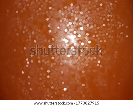 blurred sparkles of decorative lights background in orange color