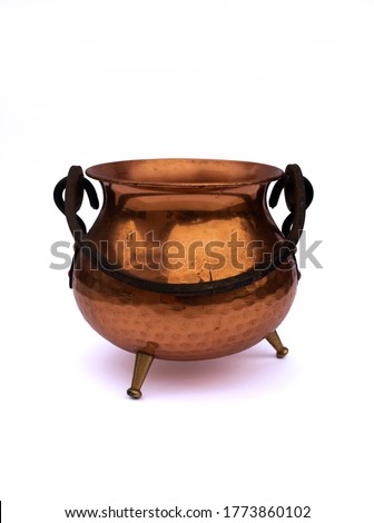 Old antique copper / bronze pot / cauldron / kettle with black holder and three small legs isolated on white studio background Royalty-Free Stock Photo #1773860102