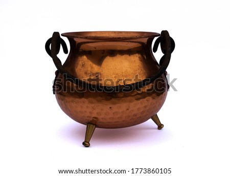 Old antique copper / bronze pot / cauldron / kettle with black holder and three small legs isolated on white studio background Royalty-Free Stock Photo #1773860105