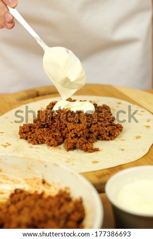 Adding tablespoon of sour cream into stuffing (ground beef). Making enchilada tortilla with beef. Series.