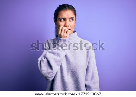 Young beautiful woman with blue eyes wearing casual turtleneck sweater over pink background looking stressed and nervous with hands on mouth biting nails. Anxiety problem.