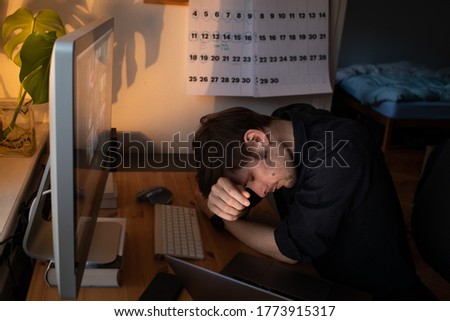 Burnout at work. Tired and fatigued  office worker sleeping on his work desk while having a video call via a computer in the home office. Remote team meeting video online conference. Problems at work Royalty-Free Stock Photo #1773915317