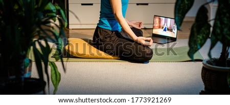woman doing yoga at home surrounded by plants