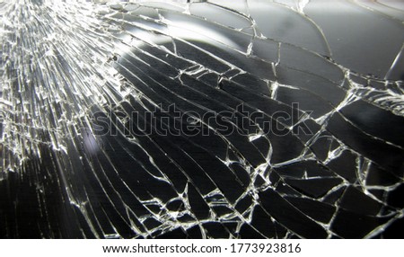 Broken smartphone display close-up. Cracks in the glass. Black glass with cracks.