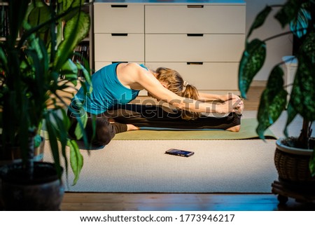 woman doing yoga at home surrounded by plants