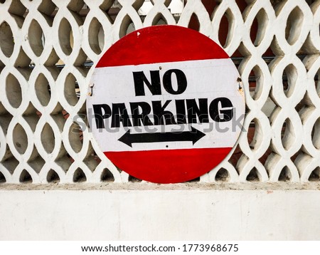 A No Parking Sign on a white wall in the city of Pondicherry in India.