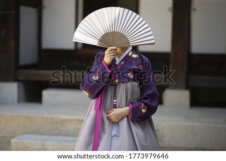 Woman in Korean traditional clothes holding Korean traditional fan Royalty-Free Stock Photo #1773979646