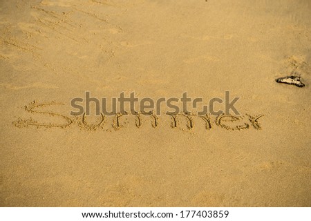 Inscription of summer on wet beach sand