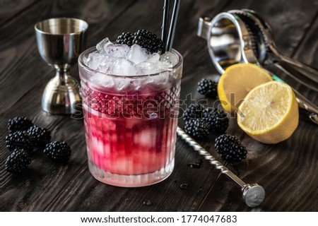 Glass of Bramble cocktail made of gin, lemon juice, sugar sypup and creme de mure Royalty-Free Stock Photo #1774047683