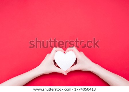 Woman holding decorative heart on red background, top view. Space for text