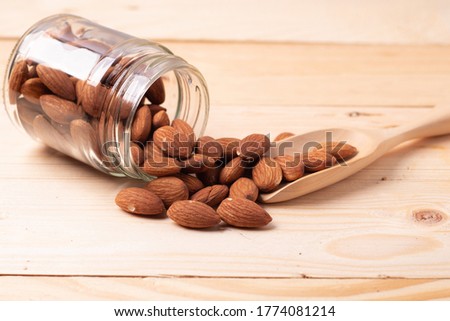 Almond in a glass bottle on a wooden background