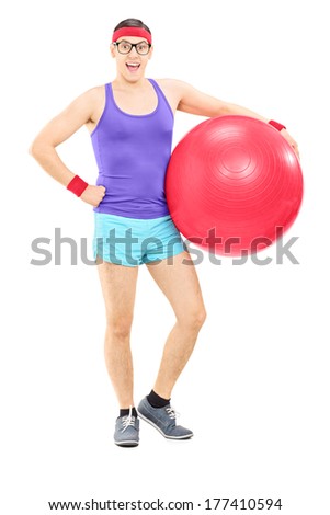 Full length portrait of a happy guy in sportswear holding a fitness ball isolated on white background