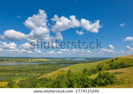 Summer landscape, river a large natural stream of water flowing in a channel to the sea, a lake, or another such stream. flood, nulla, effluent, ford. High hilly shores