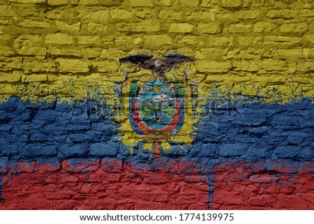 colorful painted big national flag of ecuador on a massive old brick wall