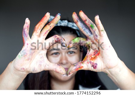 Happy woman hiding the face with her painted hands. Creative, art, drawing concept