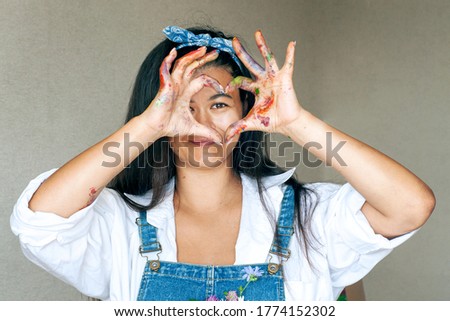 Happy woman hiding the face with her painted hands. Creative, art, drawing concept