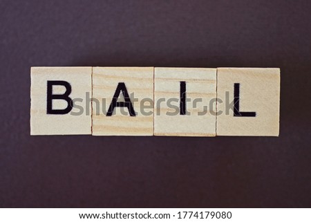 gray word bail made of wooden square letters on brown background