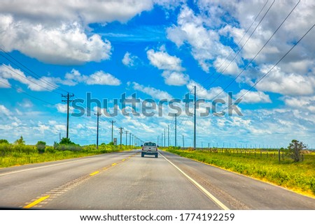A road is a route, or way on land between two places that has been paved or otherwise improved to allow travel by foot or by some form of conveyance. Roads consist of one or two roadways Royalty-Free Stock Photo #1774192259