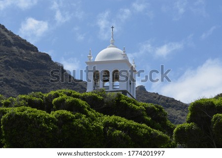 A photo of a white church dome with bells in the small town of Garachico in summer at Tenerife, Canary islands. 