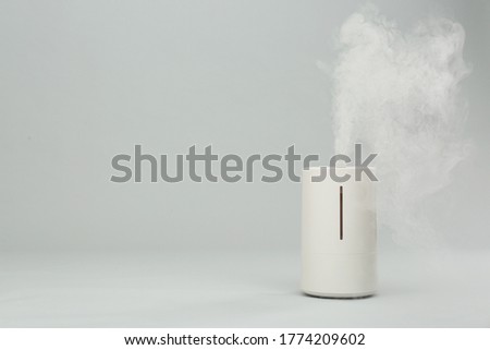 Modern air humidifier on light grey background. Space for text Royalty-Free Stock Photo #1774209602