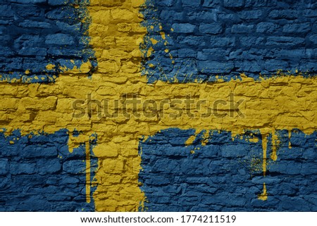 colorful painted big national flag of sweden on a massive old brick wall