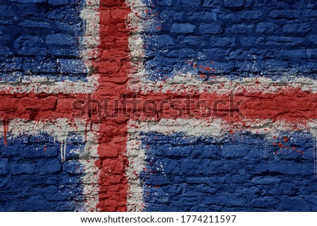 colorful painted big national flag of iceland on a massive old brick wall