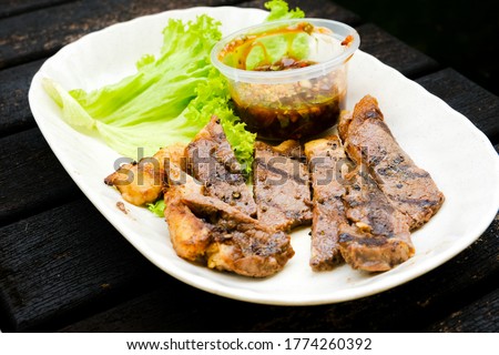 A selective focus picture of famous Malaysian adopt Thai recipe call "daging harimau menangis" in beef version. Grilled chuck lamb eat with special sweet sour salty spicy sauce.