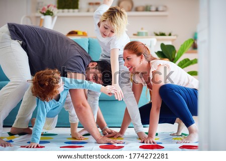 cheerful family having fun, playing twister game at home Royalty-Free Stock Photo #1774272281