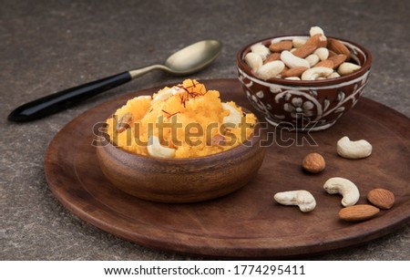 Plain or Saffron flavoured Semolina / Soji Halwa also known as Sweet Rava Sheera OR Shira - Indian festival sweet garnished with dry fruits. Served in awooden  plate or Bowl, selective focus Royalty-Free Stock Photo #1774295411