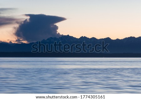 Close long exposure shot of Olympic park mountains, evening sea and clouds in Picnic Point area, WA, USA