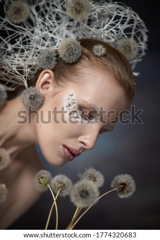 Beautiful young girl with dandelions. Flying Dandelions.