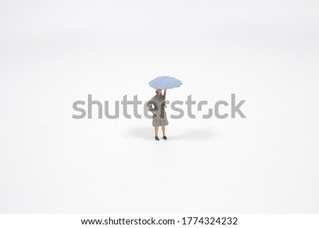 the mini figure walk ubder the rain with umbrella,